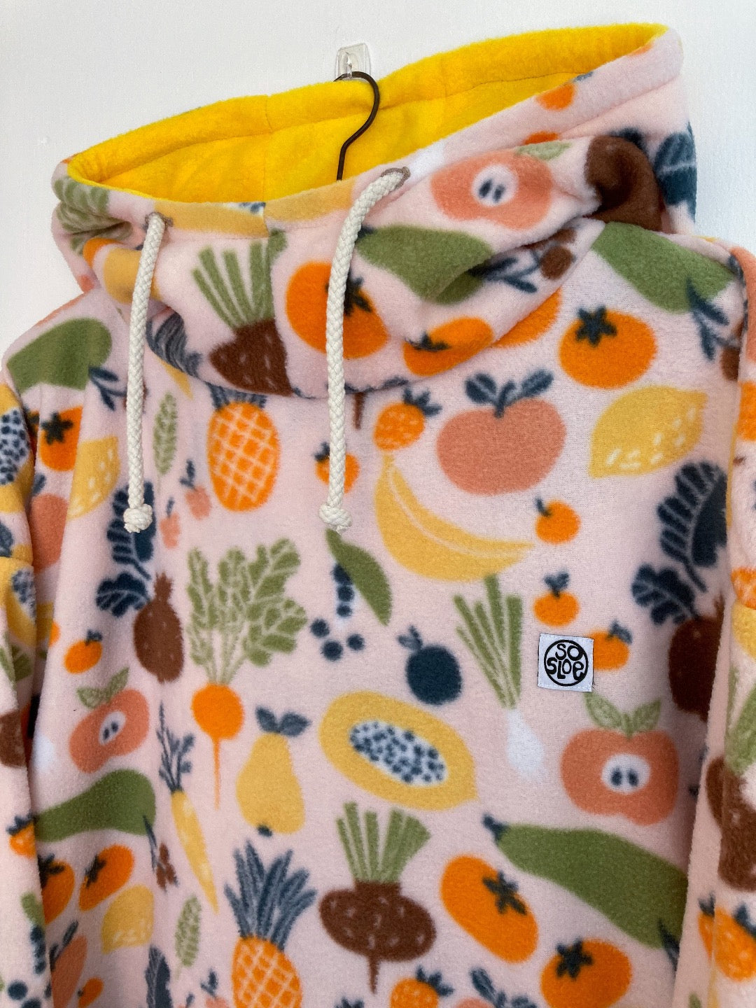 Fruit and veggies fleece with yellow lined hood and cuffs.