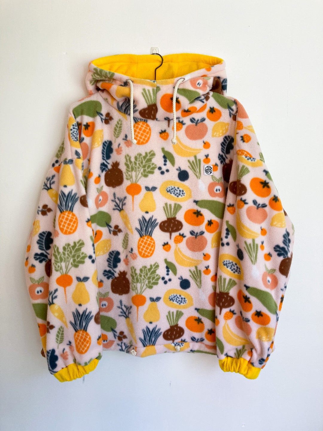 Fruit and veggies fleece with yellow lined hood and cuffs. 