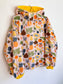 Fruit and veggies fleece with yellow lined hood and cuffs.