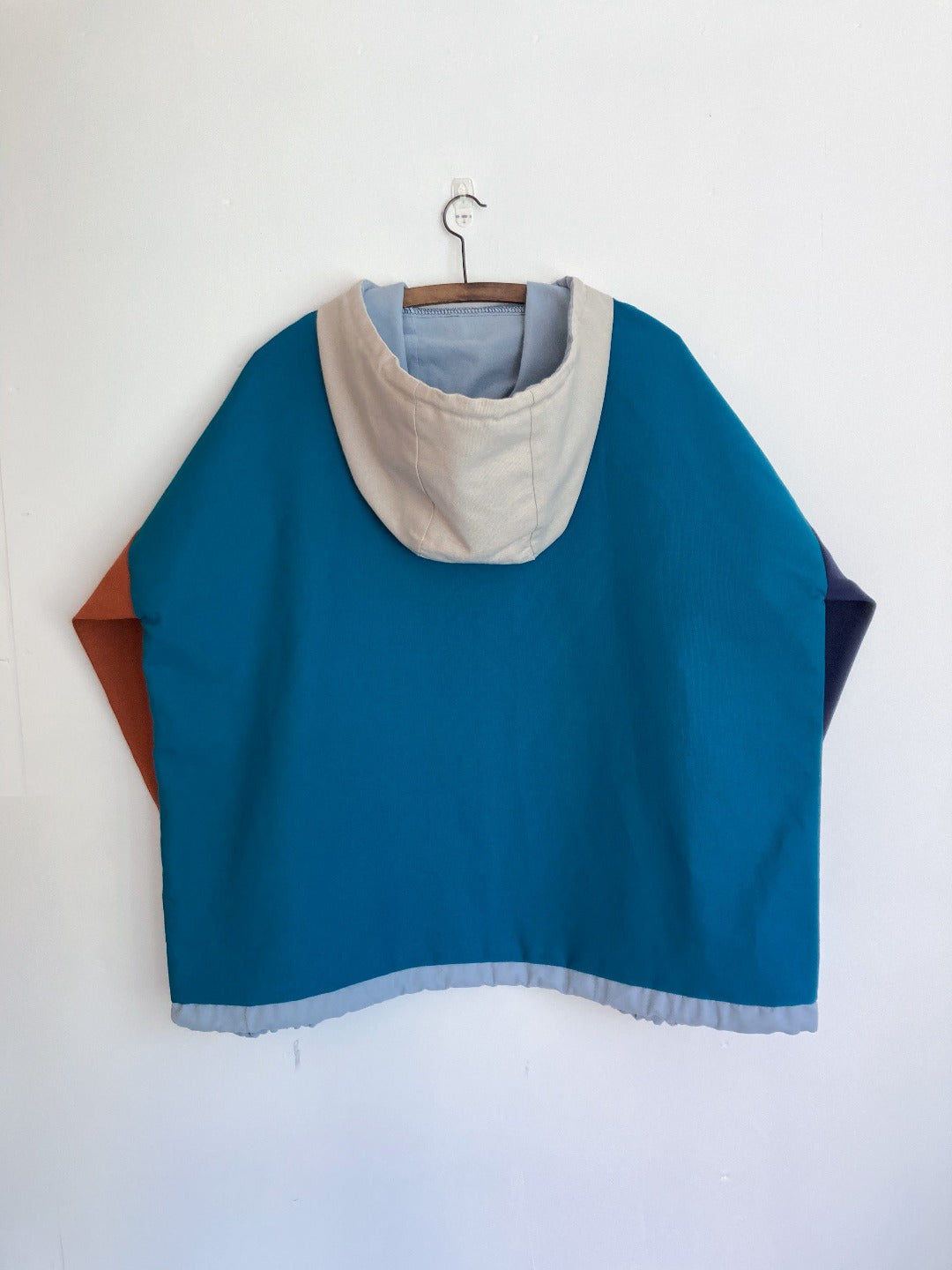 Block panel hooded pullover, teal, orange, stone and blue.